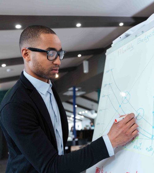Businessman making presentation on the flipchart Businessman making presentation of a business plan on the flipchart